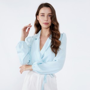 ライトブルーのショールカラーの襟エレガントなファッションのオフィスは、女性の長袖ブラウスを着用